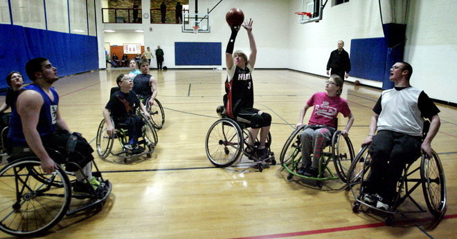James McClusky (center) takes a shot during a scrimmage of wheelchair basketball players at the West Suburban YMCA on April 11, 2013.